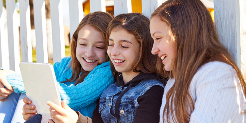 Drei Mädchen schauen auf ein Tablet